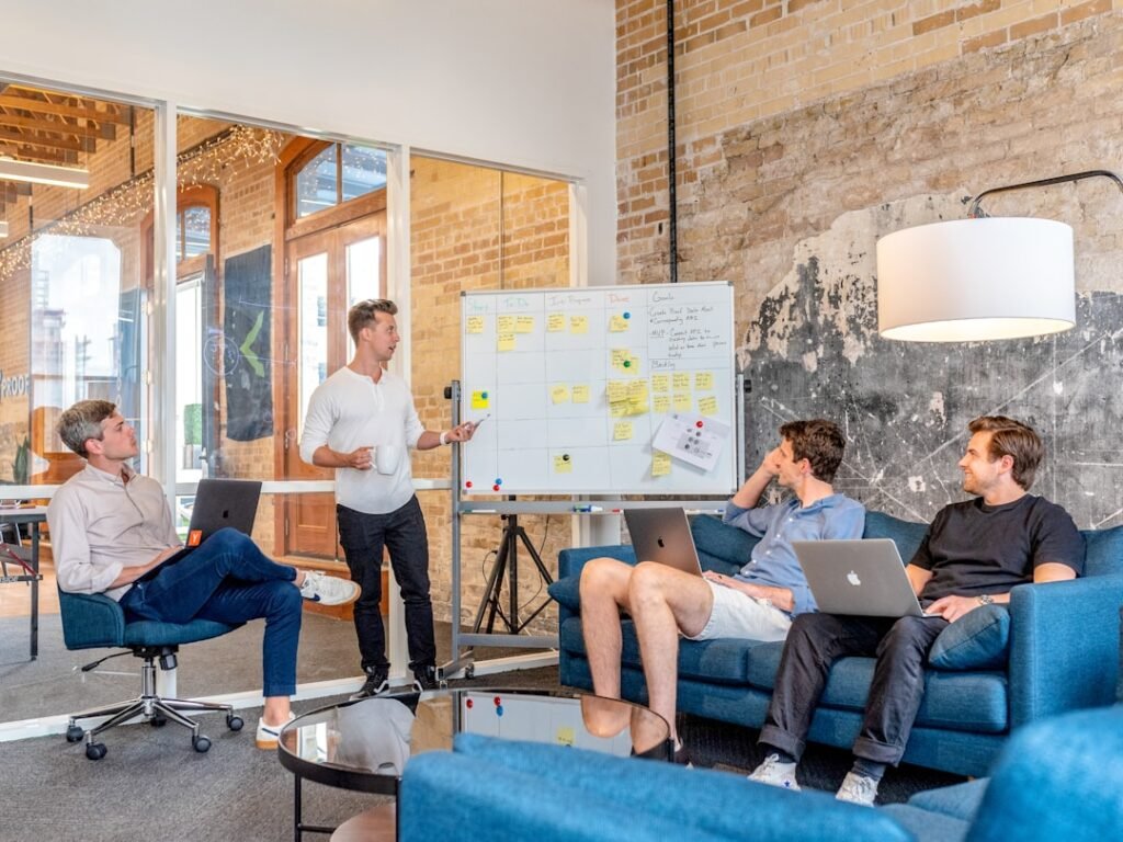 Business team meeting around laptops with whiteboard presentation