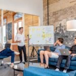 Business team meeting around laptops with whiteboard presentation
