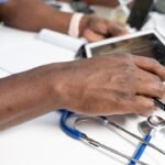 Healthcare professional using a laptop in a clinical setting