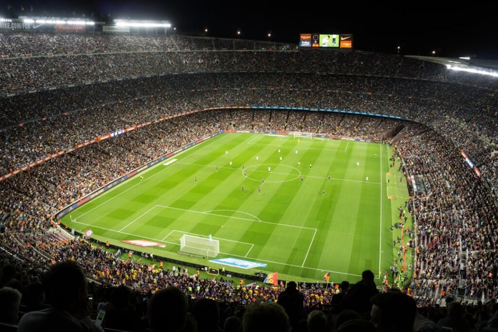 Football stadium packed with fans at kick-off under floodlights