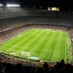 Football stadium packed with fans at kick-off under floodlights
