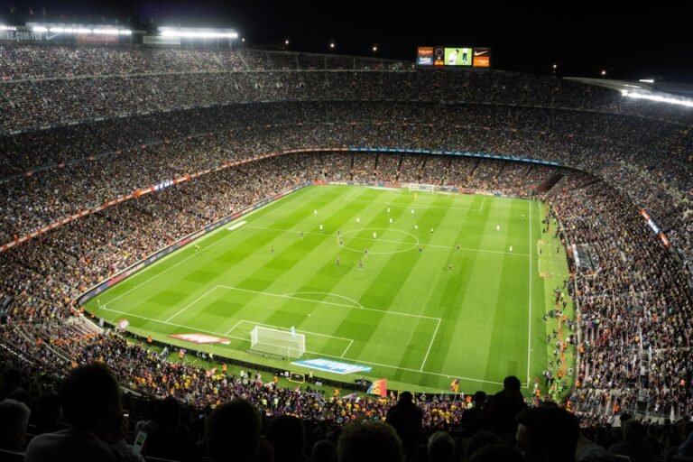 Football stadium packed with fans at kick-off under floodlights