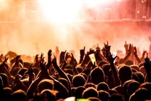 Crowd cheering at a live concert with stage lights